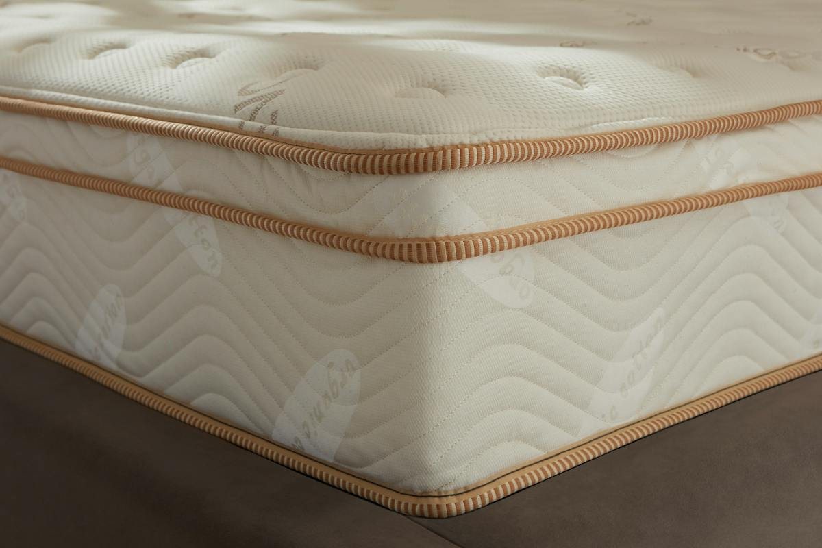 Close-up of the corner of a Saatva Classic mattress showing its quilted pillow top and gold piping